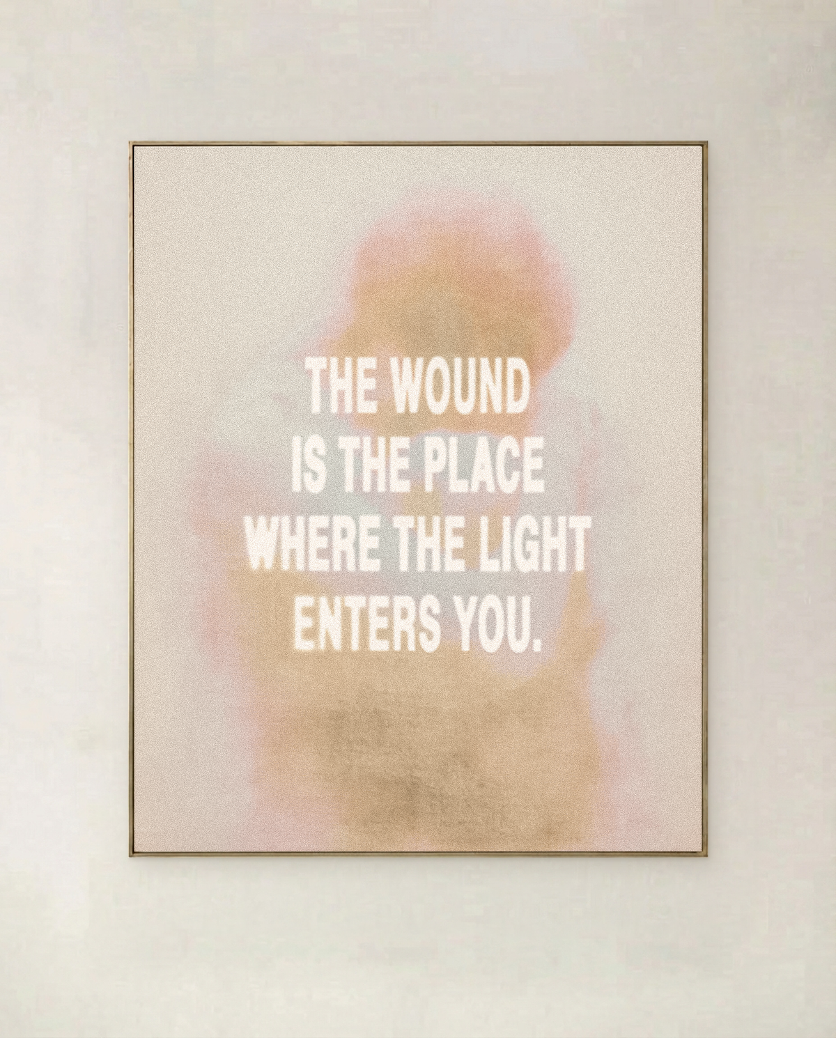 Where The Light Enters - typographic art print in soft blush and gold haze, shown in a thin gold frame on a pale wall